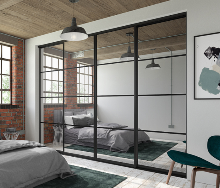 Crittall-style sliding wardrobe doors with Silver mirror panels and Black frames and tracks.